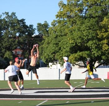 John Isner takes time out to play touch football with some junior tennis players.
